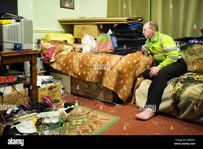 single man using computer in untidy bedsit Stock Photo - Alamy