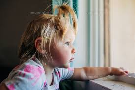 Blue eyed toddler girl looks out front window of Phoenix  house[11100148395]の写真・イラスト素材｜アマナイメージズ