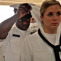 Chief Aviation Boatswain's Mate Cedric Williams inspects the uniform of  Naval Aircrewman (Mechanical) 3rd Class Kellie Cox during a dress white  inspection.