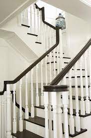 A White Staircase With White Spindles Is Contrasted With Dark Brown Treads And A Dark Brown Handrail Hardwood Stairs Handrail Design Stairs And Doors