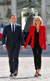Wearing a chic black coat with brown, white, and black leather. Why Every Woman Needs A Brigitte Macron Style Hero Jacket In Her Working Wardrobe