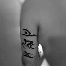 The center of this tattoo represents triathlon, with a stylized runner, waves and bike radiuses surrounded by a sun for positivity and success and by the maorigrams of the letters j, m and s. Top 75 Ironman Triathlon Tattoo Ideas 2021 Inspiration Guide Tattoos For Guys Triathlon Tattoo Tattoos