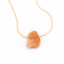 An uncut, unpolished stone containing what appears to be sunstone. Raw Sunstone Necklace Sacral Chakra Healing Crystal Necklace Orange Rough Gemstone Crystal Nugget Boho Style Layering Jewelry