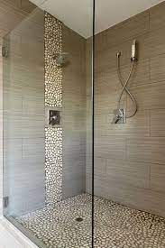 Finish the design by using basic, white subway tiles to frame the focal wall. Jolie Salle De Bain Beige Carrelage Galet Sur Le Sol Cabine En Verre Bathroom Shower Design Modern Bathroom Decor Modern Shower