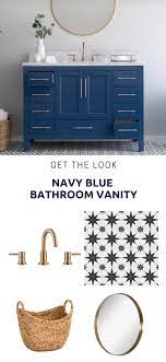 White and blue bathroom boasts a blue vanity adorned with gold pulls topped with gray quartzite fitted with a rectangular white porcelain sink and a. Navy Blue Vanity Style Navy Blue Bathrooms Blue Bathroom Blue Bathroom Vanity