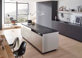 Modern stainless steel, dark wooden island unit with open drawer and fresh vegetables and onions on chopping board. Stone Worktops Natural Stone Worktops Lechner