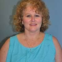 A woman sitting at a desk in front of a computer. Woman office teacher,  beauty fashion.