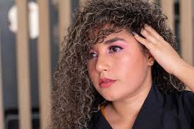 Retrato de uma linda mulher de cabelos cacheados posando e exibindo sua linda  nova cor de cabelo