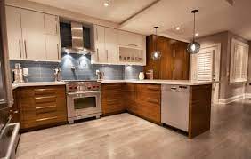 Sleek white kitchen illuminated by modern pendant lights that hung over the peninsula with black bar stools. Modern Lighting Blog Modern Kitchen Flooring Kitchen Design Kitchen Peninsula