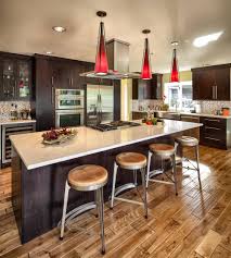 In this kitchen a trio of hanging black metal and glass antique lanterns hangs over the kitchen island with its salt and pepper granite countertop and intricately carved white painted wooden plinth and body. Dark Cabinets Light Floor Houzz