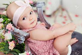 Small Very Cute Wide Eyed Smiling Baby Girl In A Pink Dress Is In The Chair About Pink Flowers Stock Photo Picture And Royalty Free Image Image 72682175