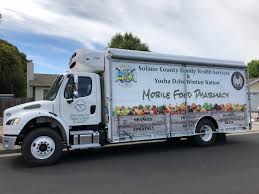 Young man counting money while standing in line at food truck. Solano County Mobile Food Pharmacy