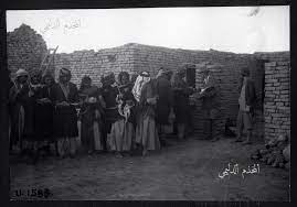 صورة من التراث العراقي لعمال يعملون في التنقيب عن الاثار في منطقة اور سنة 1930 ويظهر وهم يقفون لاستلام اجورهم woolley inspecting artifact photo image history