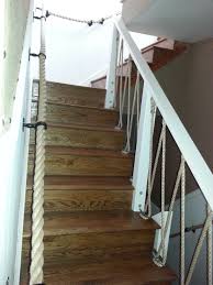 This staircase by jonathan adler not only has a rope railing, but also a graduating blue for the front of the steps to enhance the nautical appeal. Rope Handrail Stairs Countrusitcal Design Country Rustic Nautical Stairs Beach House Decor Staircase Railings