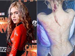 That's one possible theory after dissecting her massive new back tattoo, which she describes as beautiful alien scars.. Grimes Unveils Beautiful Alien Scars Tattooed Across Her Back The Independent