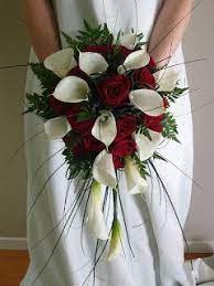 The handle is wrapped in ivory satin ribbon with a plum purple. Possibly Too Pokey Wedding Bouquet Red Roses And White Calla Lilies Red Bouquet Wedding Wedding Flower Arrangements Teardrop Bouquet