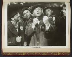 Danny Kaye mock-fighting surrounded by men