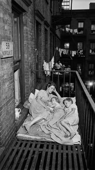 Mother and children sleeping on a fire escape in 1930s NYC