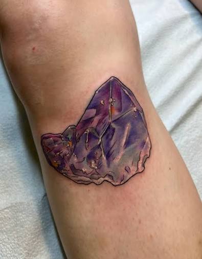 a quartz cluster where one of the points is amethyst, a memorial for my wonderful client Megan 🤍💜🩵 What kind of crystal would you have me tattoo? I'd love to do more