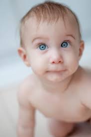 Little girl looking at the camera smiling with her mouth open and her head  slightly tilted to the side. by Marcela Limon. Photo stock