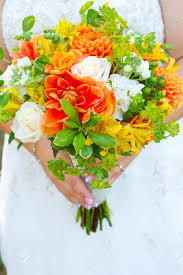 The green wedding bouquet may feature lovely green crysanthemums with darker green foliage, but are often garnished with soft white flowers or even pearls particularly if pearls feature elsewhere in the gown or veil. A Bride In Her White Wedding Dress Holds Her Bouquet Of Orange Green And Yellow Flowers On Her Wedding Day Stock Photo Picture And Royalty Free Image Image 16917658
