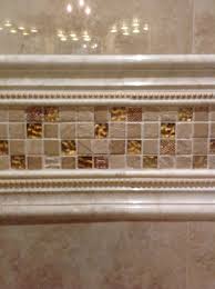 These mosaic listello's are employed to give a break to the running design and pattern. I Love The Gold Trim Tile That Goes From Wall To Wall And Above The Granite Countertop It S Made Up Of A Marble C Pencil Tile Master Bath Remodel Shower Tile