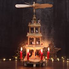 They comprise a decorated pyramidal outer frame with candle holders and a central carousel with a rotor at the top which is driven by warm air from the lit candles. German Christmas Pyramid 4 Tier