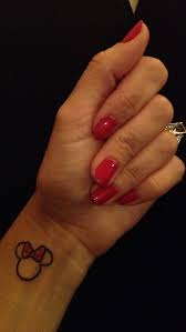 Blue bows with lines a pair of blue bows pictured on the wearer's thighs lead to solid blue lines that run down the wearer's legs. Minnie Mouse Wrist Tattoo With Polkadot Bow Minnie Tattoo Mouse Tattoos Mini Tattoos