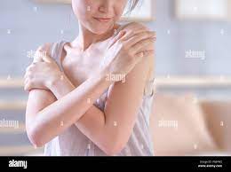 young woman touching her shoulder prouding with her healthy skin after  applying the cream Stock Photo - Alamy