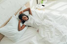 Sie würde in wenigen tagen. Draufsicht Auf Frohliche Schone Afrikanisch Amerikanische Madchen Die Lachelnd Im Bett Liegen Lizenzfreies Foto Und Stockbild