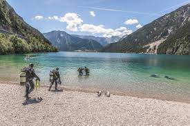 Town at the other end of the lake with a beach. Zu Schatzen Tauchen