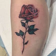 The palette of colors is quite dark, and an absolutely stunning rose tattoo is on a woman's thigh. Top 91 Best Red Rose Tattoo Ideas 2021 Inspiration Guide