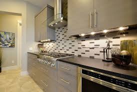 Under Cabinet Lighting With Outlets With Contemporary Kitchen Also Beige Tile Floor Black Tile Backsplash Cooktop Gray Cabinets Gray Drawers Gray Tile Backsplash Gray Wall Range Hood Stainless Steel Under Cabinet Lighting