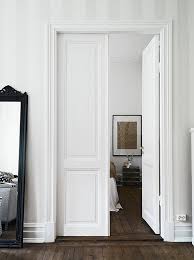 A compact yet stylish living room with nicely set up white furniture including sofas, seats and white cabinets. Classic White Living Room Double Doors Interior Wood Doors Interior Doors Interior