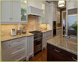 The white square tiles with a motif of quarter circles by fireclay tile are randomly placed onto the wall in this kitchen in a house in the hamptons. White Glass Tile Kitchen Backsplash