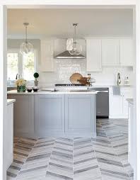 More dramatic shades of matt grey create instant impact, while the metallic shine of chrome and steel creates a clean, modern aesthetic. Gray Chevron Pattern Floor Tiles With Gray Island Transitional Kitchen