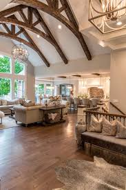 This spacious bedroom features white shiplap walls, hardwood flooring, a gray area rug, a sleigh bed backing up to four windows, and a high ceiling with black ceiling fan. 10 Reasons To Love Your Vaulted Ceiling