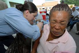Hospital Corpsman 3rd Class Michelle Tilley, attached to Military Sealift  Command hospital ship USNS Comfort (T-AH 20), gives a patient an  immunization shot at the Arima Health Facility.