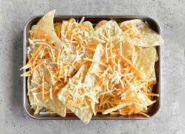 Cheese nachos is a mexican dish made with tortilla chips and topped with veggies and melted cheese. Nachos Recipe The Gunny Sack