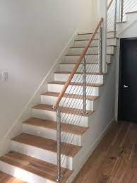 Our Stainlesssteel Wire Rope Railing With Wood Rail Makes A Modern Statement All Can Appreciate Stairs Design Modern Staircase Design Stair Railing