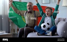 Grandpa and grandson watching football, waving Portuguese flag, happy for  win Stock Photo - Alamy