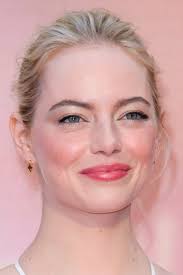 Did you know that her natural hair color is blonde? Emma Stone Wavy Platinum Blonde Bun Dark Roots Hairstyle Steal Her Style