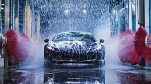 A car being washed in an automated car wash with soap and water spraying  everywhere. 60508470 Stock Photo at Vecteezy
