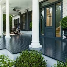 The Front Porch Of A Home With White Pillars Navy Floor And A Blue Front Door House With Porch Painted Front Porches Porch Colors