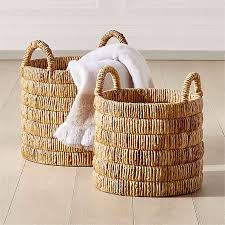 A container made of interwoven strips of pliable materials, such as cane, straw, thin wood, or plastic, and often carried by means of a handle or handles 2. Storage Baskets Metal Rope Jute And More Cb2 Canada