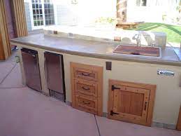 If you can find steel doors that fit your design, they're the most durable option. 2 Tone Island With Wood Doors Outdoor Kitchen Cabinets Patio Storage Wood Cabinet Doors
