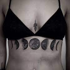 Phases Of The Moon Tattoo Under The Breasts Black Bra Girl Chest Tattoos Grey Background Chest Tattoos For Women Tattoos For Women Tattoos