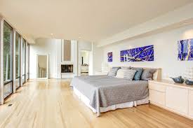 This bedroom features a light gray walls and white ceiling along with a hardwood flooring lighted by a beautiful chandelier. Light Wood Floor Bedroom Ideas Design Corral