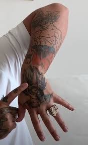 Black small tribal shape dragon tattoo design on shoulder of a men looking awesome. Untold Stories And Meanings Behind Anuel Aa S Tattoos Tattoo Me Now