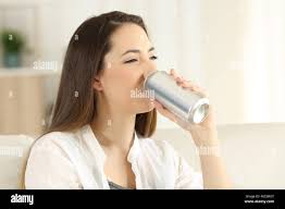 Ritratto di una donna felice di bere una soda ristoro da una possibile  seduta su un divano nel salotto di casa Foto stock